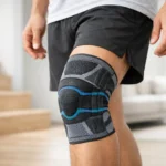 Person trägt eng anliegende Kniebandage beim Treppensteigen in hellem Wohnraum mit Sportkleidung an!