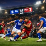 Dramatische Spielszenen zwischen KSC und FC Augsburg im Flutlichtstadion mit jubelnden Fans.