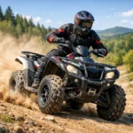 Ein Quad-Fahrer fährt über staubiges Gelände, umgeben von grünen Wäldern und Hügeln im Hintergrund.