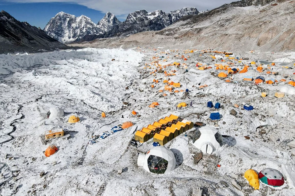 Basislager am Mount Everest mit bunten Zelten auf schneebedecktem Gletscher und hohen Bergen, weite.