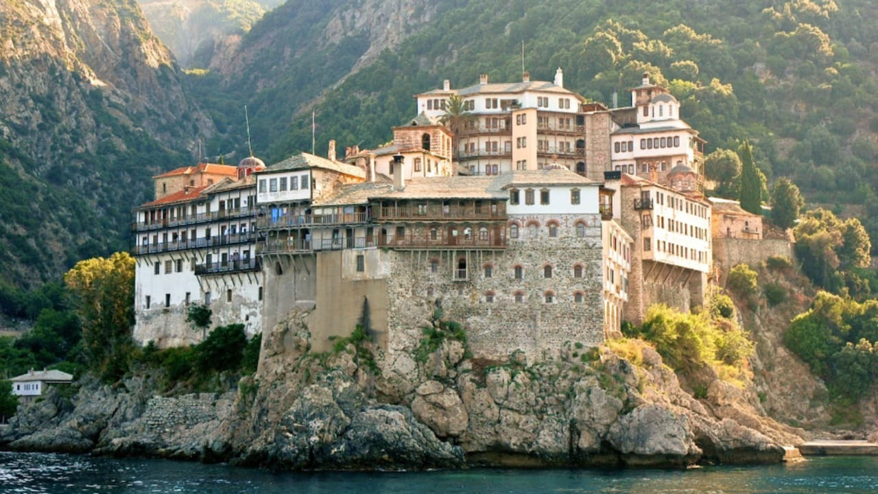 Kloster auf dem Berg Athos an felsiger Küste nach Erdbeben in Griechenland bei sonnigem Wetter.