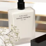 Narciso Rodriguez Pure Musc Flakon auf edler Ablage mit weißen Blüten in stilvoller Atmosphäre